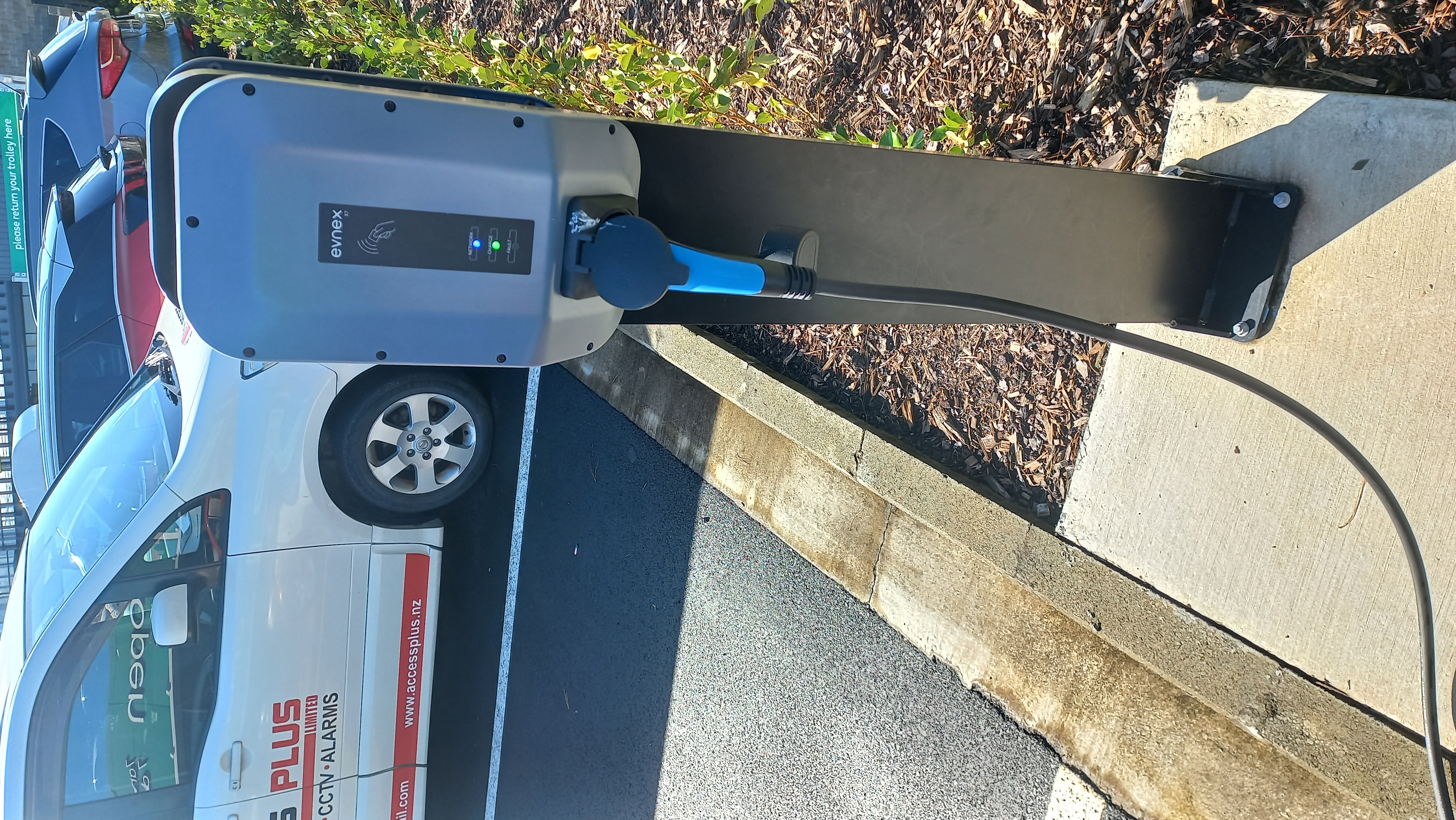 An electric vehicle charging at a wall-mounted station in a home garage